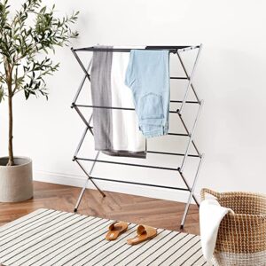 A laundry drying rack with clothes and room